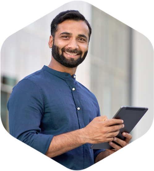 A man happily using a tablet computer while enjoying the outdoors.